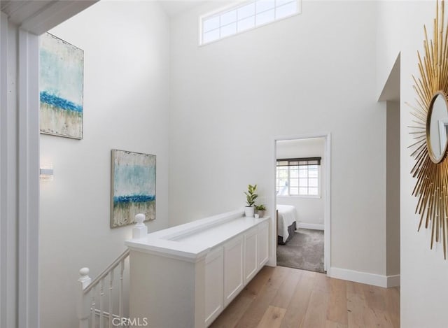 33156 Ocean Bright, Dana Point, CA 92629 - corridor featuring light wood-type flooring, an upstairs landing, a high ceiling, and baseboards