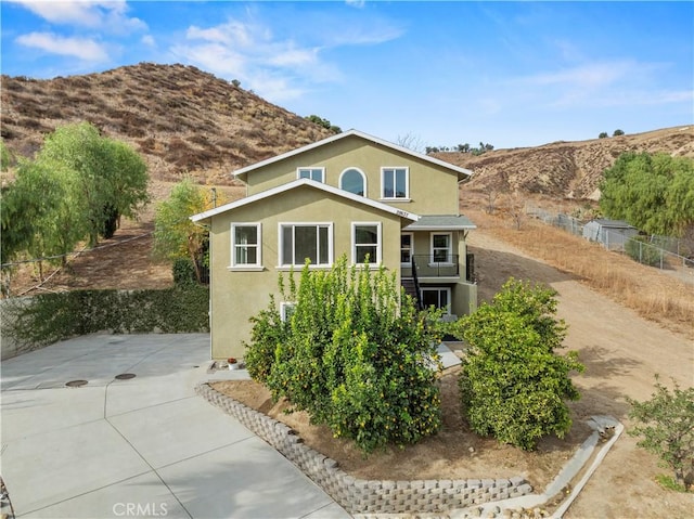 28637 Chiquito Canyon Rd, Castaic, CA 91384 - view of front of house with stucco siding, a mountain view, and fence