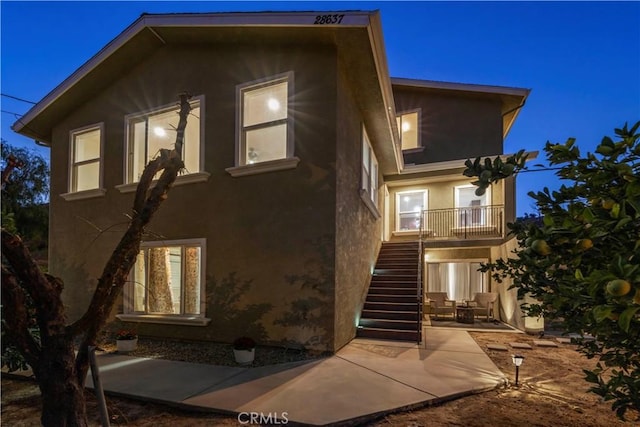 28637 Chiquito Canyon Rd, Castaic, CA 91384 - property exterior at night featuring stairway, stucco siding, and a patio area