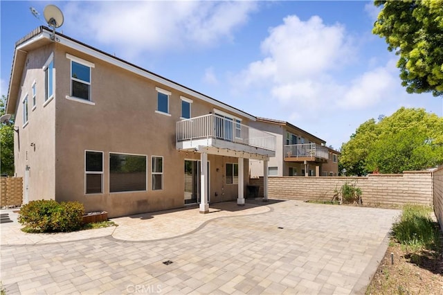 27952 Agapanthus Ln, Valencia, CA 91354 - rear view of property featuring stucco siding, fence, a patio, and a balcony