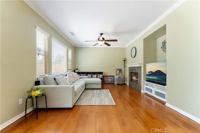 27952 Agapanthus Ln, Valencia, CA 91354 - living area featuring wood finished floors, ceiling fan, ornamental molding, a tile fireplace, and baseboards