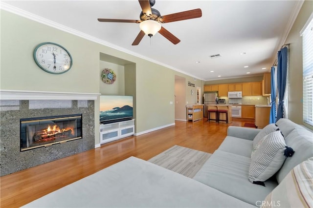 27952 Agapanthus Ln, Valencia, CA 91354 - living room with light wood-style flooring, baseboards, crown molding, ceiling fan, and a fireplace