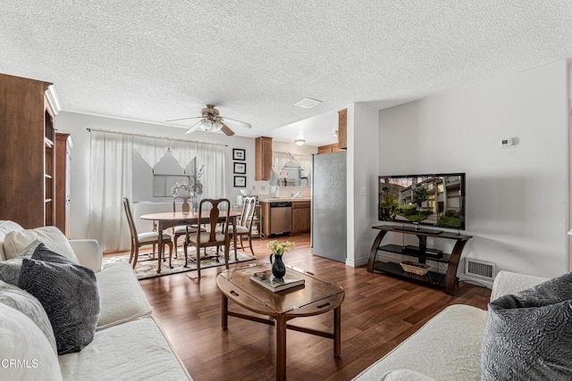 living room featuring a ceiling fan, wood finished floors, and a textured ceiling