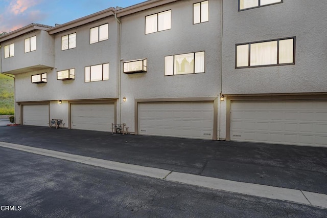 rear view of house featuring stucco siding and an attached garage