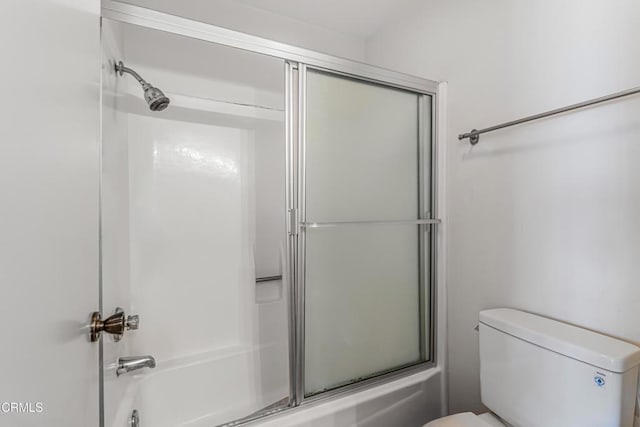 full bath featuring combined bath / shower with glass door and toilet