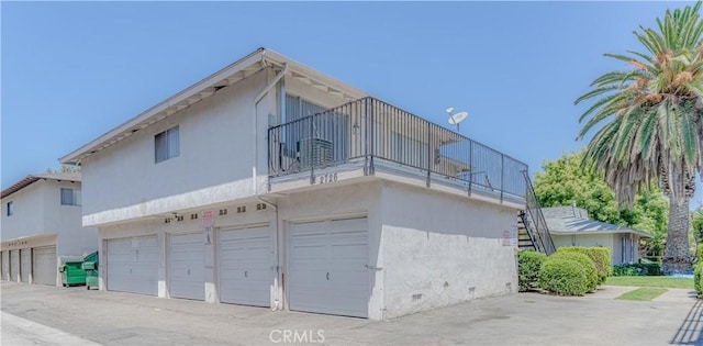 2726 W Orion Ave, Santa Ana, CA 92704 - view of side of home featuring a balcony, stucco siding, and a garage