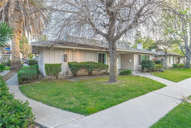 2726 W Orion Ave, Santa Ana, CA 92704 - ranch-style house with board and batten siding, a front yard, and a chimney