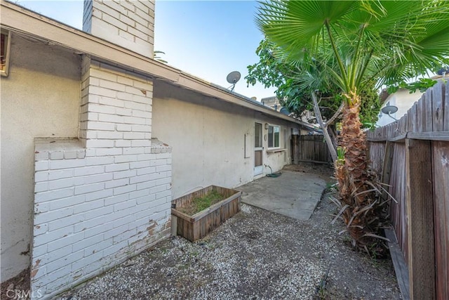2726 W Orion Ave, Santa Ana, CA 92704 - view of side of home with a chimney, brick siding, and stucco siding