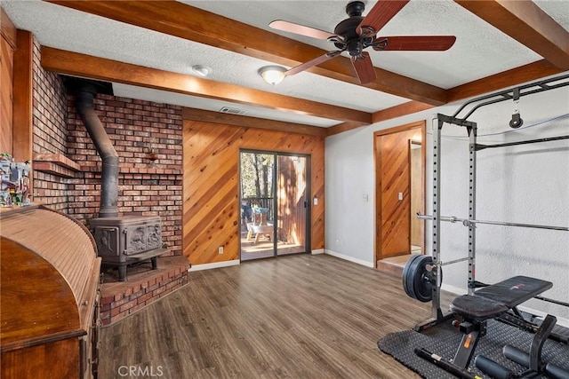 14177 Racine Cir, Magalia, CA 95954 - workout room with a wood stove, baseboards, a ceiling fan, wood finished floors, and a textured ceiling