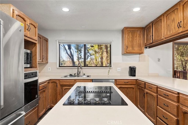 14177 Racine Cir, Magalia, CA 95954 - kitchen featuring stainless steel appliances, a sink, light countertops, recessed lighting, and brown cabinetry