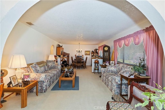 20407 Eyota Ln, Apple Valley, CA 92308 - living room featuring light carpet, a chandelier, arched walkways, and a textured ceiling