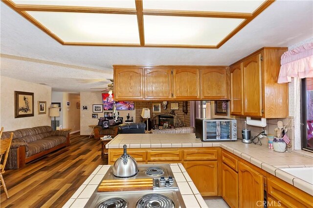 20407 Eyota Ln, Apple Valley, CA 92308 - kitchen featuring open floor plan, a peninsula, light wood-style floors, brown cabinetry, and backsplash
