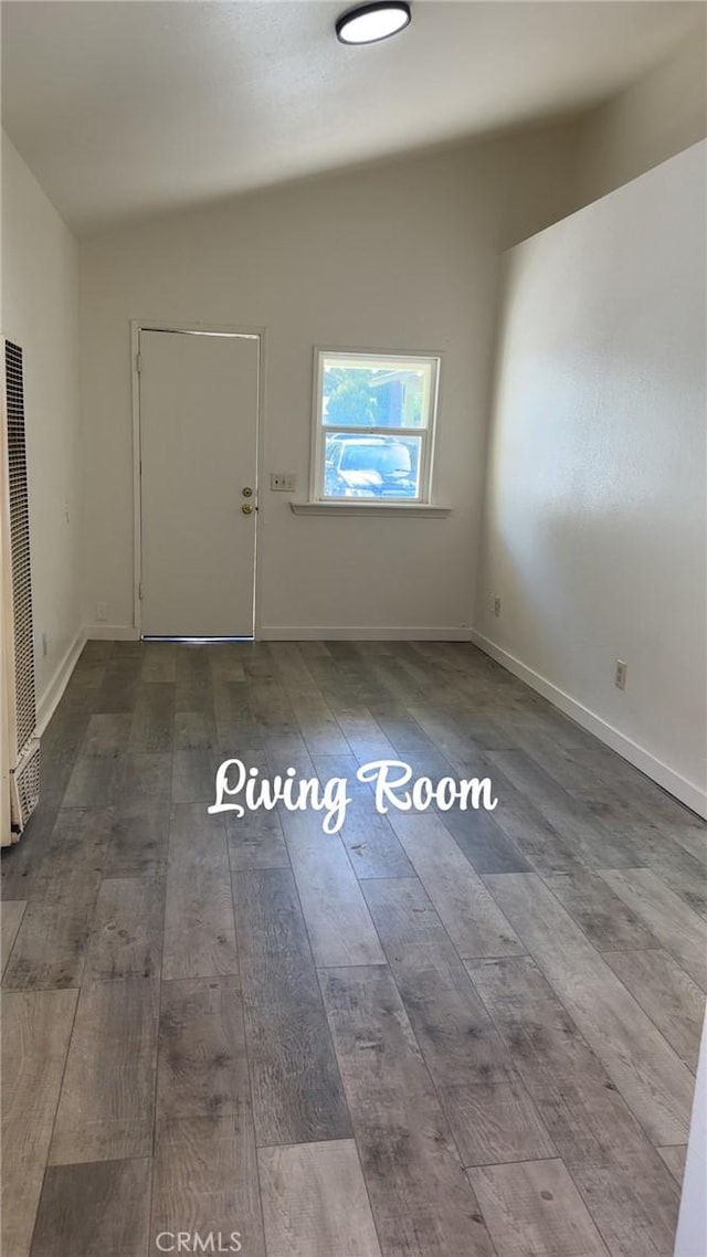 foyer entrance featuring a heating unit, wood-type flooring, and baseboards