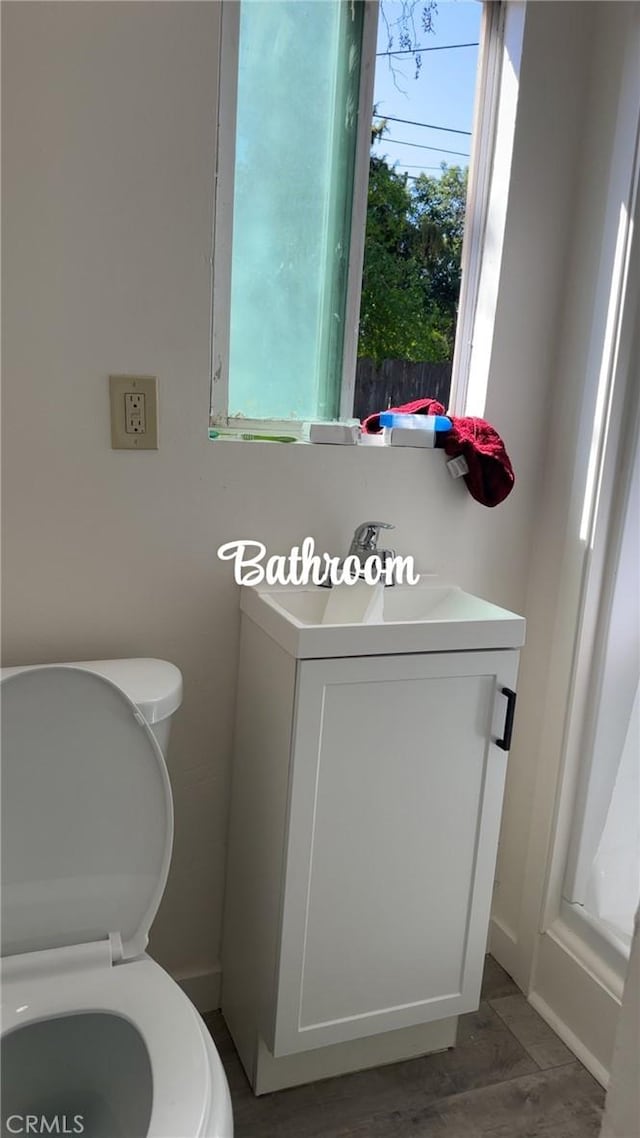 bathroom featuring plenty of natural light, toilet, and vanity