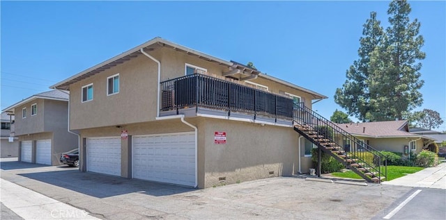 2619 W Aurora St, Santa Ana, CA 92704 - view of property exterior featuring stucco siding, stairway, crawl space, an attached garage, and driveway