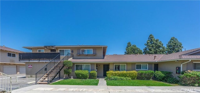 2619 W Aurora St, Santa Ana, CA 92704 - view of front facade featuring stairway, stucco siding, and a front lawn