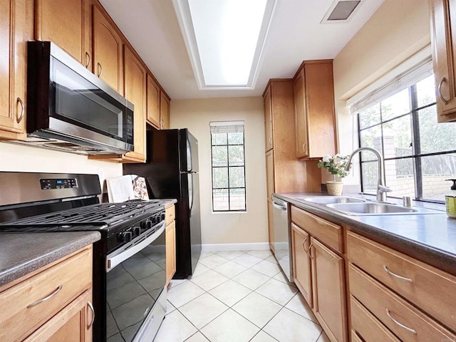 13272 Wimberly Sq Unit 219, San Diego, CA 92128 - kitchen featuring stainless steel appliances, a sink, baseboards, dark countertops, and light tile patterned floors