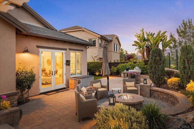3482 Corte Fortuna, Carlsbad, CA 92009 - patio terrace at dusk with french doors, a fire pit, fence, and area for grilling