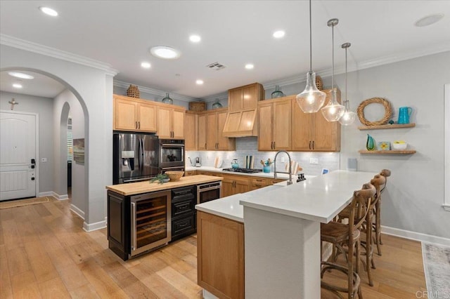 3482 Corte Fortuna, Carlsbad, CA 92009 - kitchen with wine cooler, stainless steel appliances, light countertops, premium range hood, and baseboards