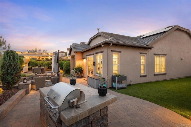 3482 Corte Fortuna, Carlsbad, CA 92009 - patio terrace at dusk featuring an outdoor kitchen, area for grilling, a pergola, a yard, and outdoor lounge area