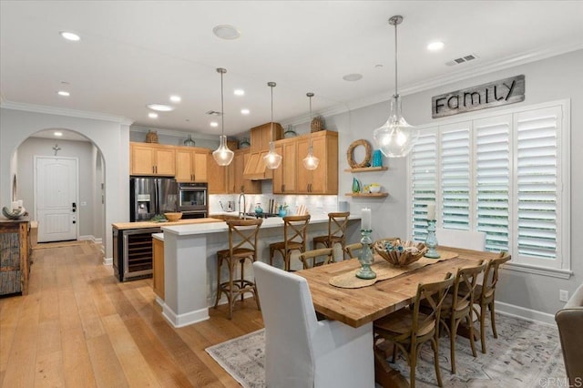 3482 Corte Fortuna, Carlsbad, CA 92009 - dining area with beverage cooler, arched walkways, light wood-style floors, ornamental molding, and recessed lighting