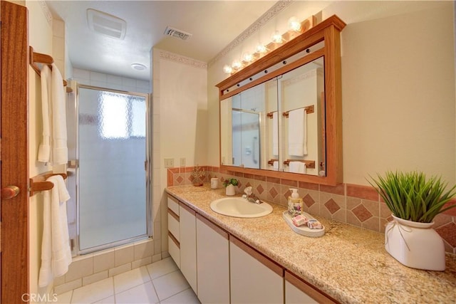 bathroom featuring a shower stall, vanity, tile patterned floors, and backsplash