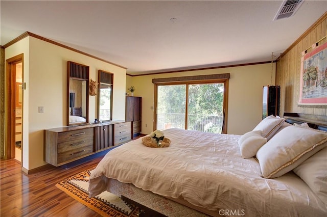 bedroom with ornamental molding, wood finished floors, baseboards, and access to outside
