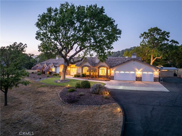 11620 Cenegal Rd, Atascadero, CA 93422 - view of front facade with driveway, an attached garage, stucco siding, a chimney, and stone siding