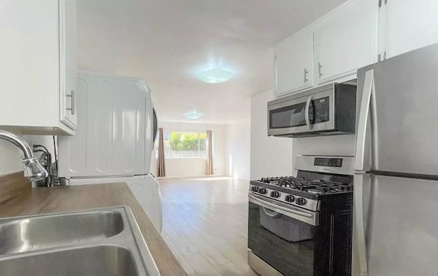 2309 Hauser Blvd, Los Angeles, CA 90016 - kitchen with stainless steel appliances, a sink, white cabinetry, and wood finished floors