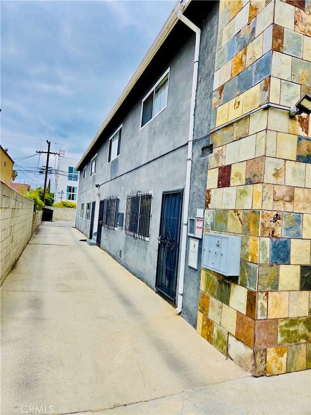 2309 Hauser Blvd, Los Angeles, CA 90016 - view of home's exterior with stucco siding, mail area, and fence
