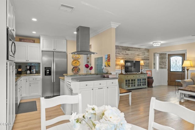 10440 N Karen Ave, Oak View, CA 93022 - kitchen featuring stainless steel appliances, island range hood, open floor plan, ornamental molding, and light wood-style floors