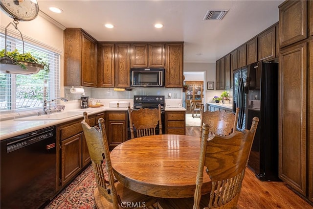 8435 Sale Ave, West Hills, CA 91304 - kitchen with black appliances, a sink, crown molding, wood finished floors, and light countertops