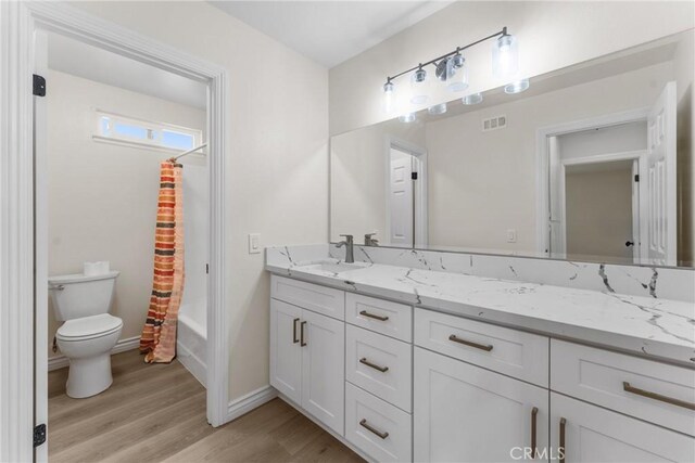 8990 19th St Unit 376, Rancho Cucamonga, CA 91701 - bathroom with wood finished floors, toilet, vanity, baseboards, and shower / bath combination with curtain