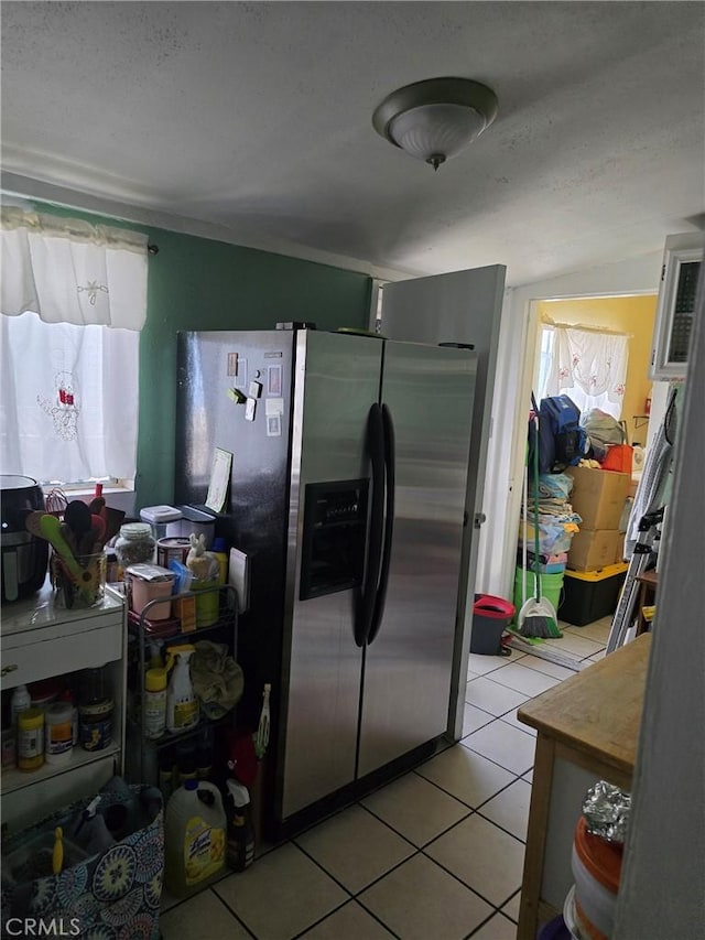 4391 Triggs St, Los Angeles, CA 90023 - kitchen featuring stainless steel fridge, light tile patterned floors, and a textured ceiling