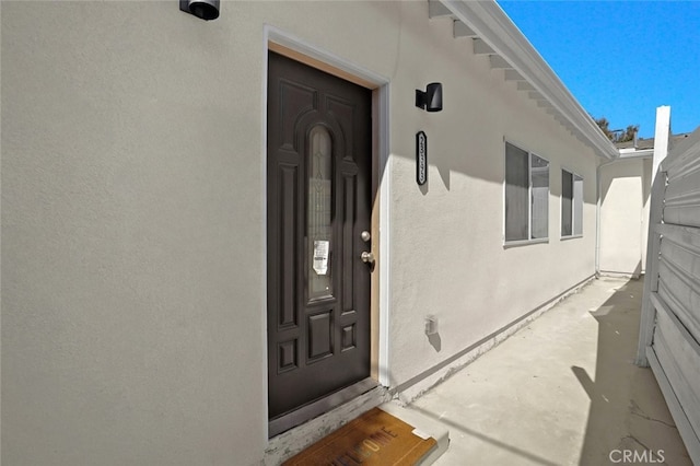 entrance to property featuring stucco siding