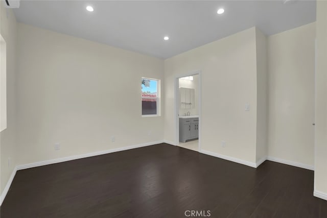 unfurnished room with wood finished floors, baseboards, and recessed lighting