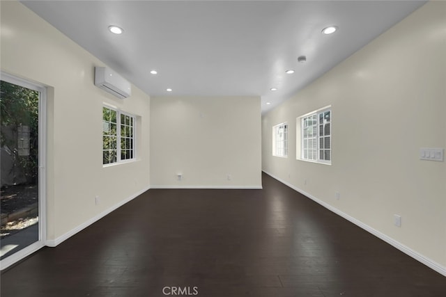 unfurnished room featuring a wall mounted air conditioner, wood finished floors, plenty of natural light, and recessed lighting