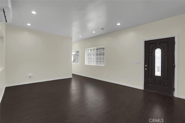 entrance foyer featuring dark wood-style flooring, a wall mounted AC, baseboards, and recessed lighting