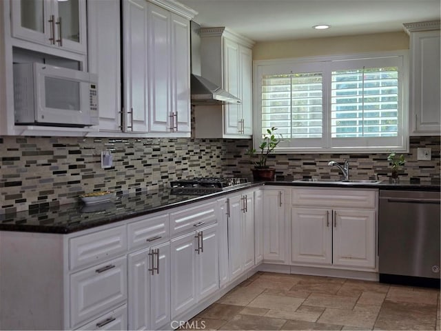 kitchen with stainless steel appliances, a sink, wall chimney range hood, backsplash, and recessed lighting