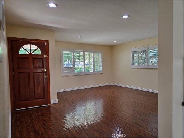 foyer with dark wood-type flooring, baseboards, and recessed lighting