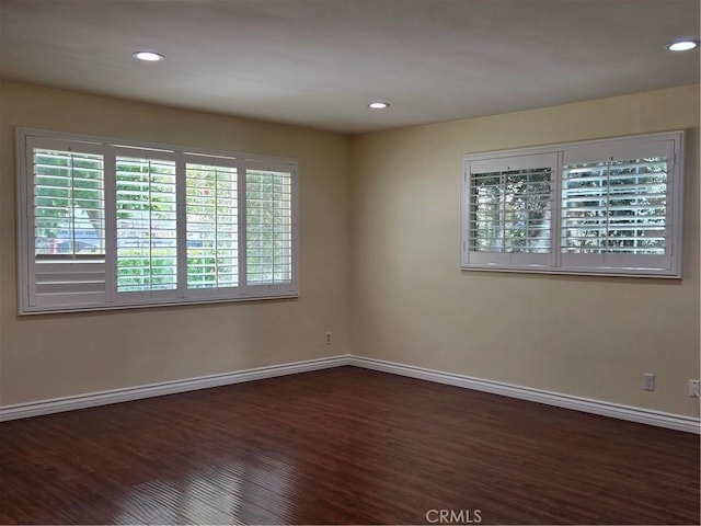 empty room with baseboards, recessed lighting, and dark wood finished floors