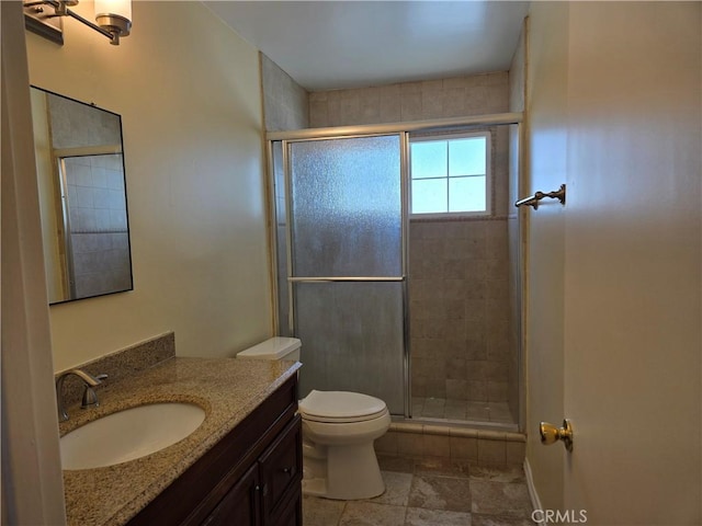 full bathroom featuring a stall shower, toilet, and vanity
