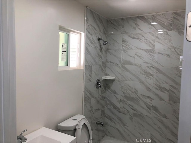 bathroom with toilet, a shower, and a sink