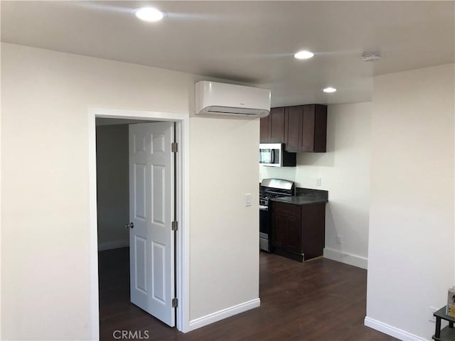 kitchen with stainless steel appliances, an AC wall unit, baseboards, recessed lighting, and dark brown cabinetry