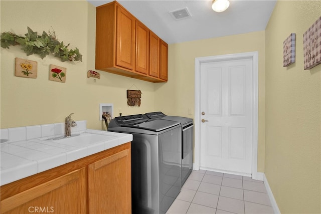 11020 Blue Jay Way, Oak Hills, CA 92344 - washroom featuring washing machine and dryer, cabinet space, light tile patterned flooring, and baseboards