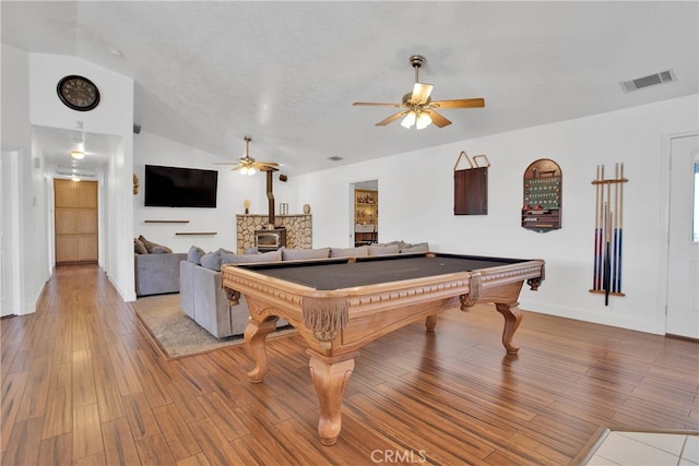 11020 Blue Jay Way, Oak Hills, CA 92344 - playroom featuring ceiling fan, a wood stove, lofted ceiling, and wood finished floors