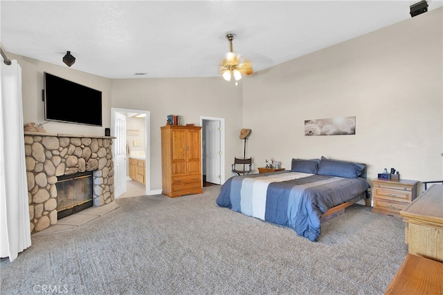 11020 Blue Jay Way, Oak Hills, CA 92344 - bedroom with carpet, a stone fireplace, vaulted ceiling, ensuite bathroom, and a ceiling fan