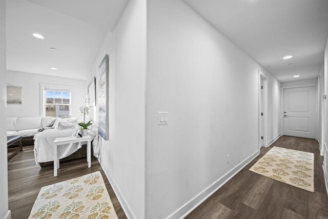 hall featuring recessed lighting, dark wood-type flooring, and baseboards