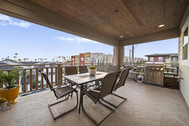view of patio / terrace with a balcony, outdoor dining space, and a residential view