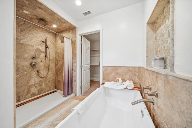 bathroom featuring a tile shower, recessed lighting, and a tub to relax in